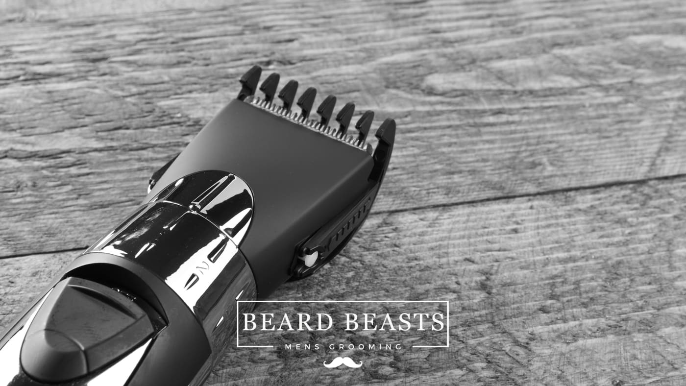 A black hair clipper with an attached guard on a wooden surface, suggesting its use for male grooming and raising the question, Can you cut wet hair with clippers?