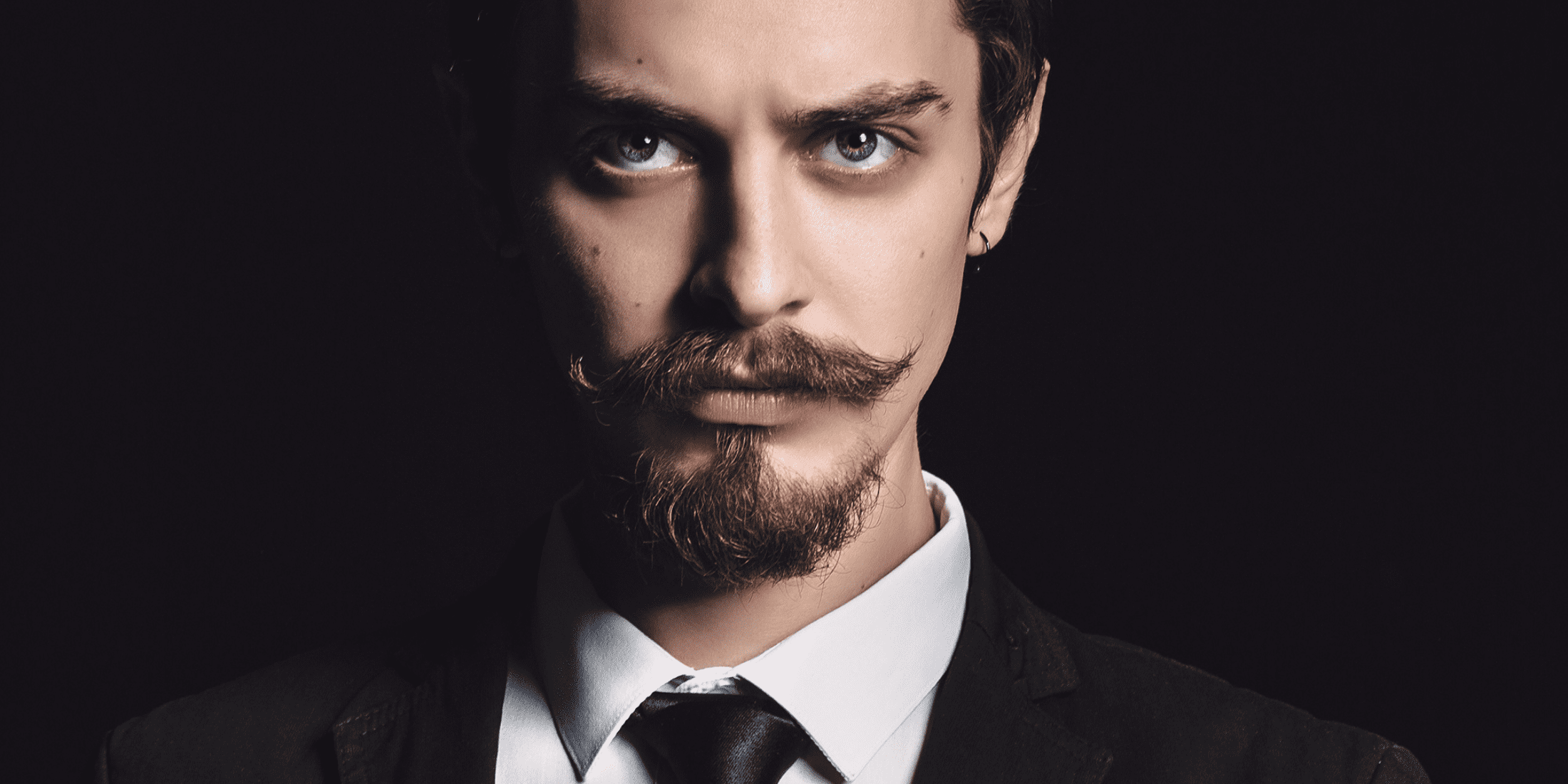 Man with an Anchor Beard - A stylish close-up of a man sporting a meticulously groomed anchor beard, featuring a pointed chin beard and a disconnected mustache, ideal for showcasing modern men's grooming trends.