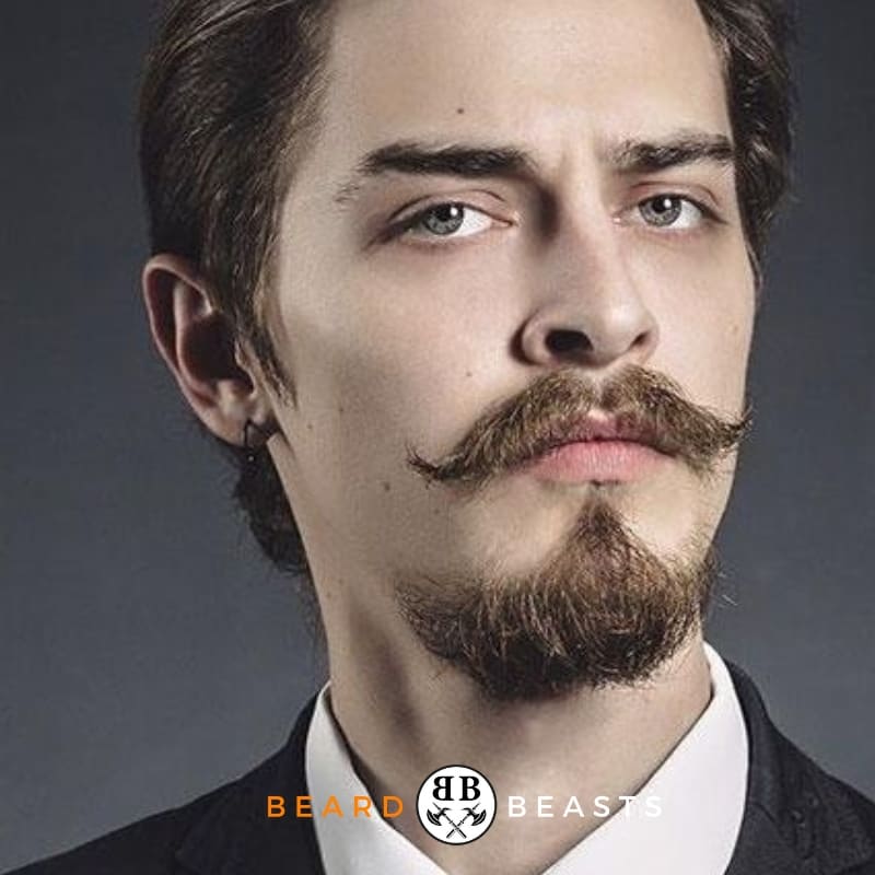 Man with a meticulously groomed anchor beard and curled mustache, dressed in formal attire, with Beard Beasts logo displayed on the image.