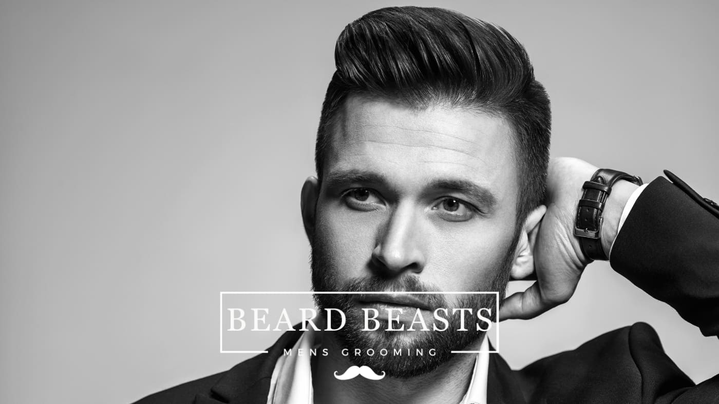 Man showcasing a sleek pompadour hairstyle, a potential result of choosing between hair putty vs pomade, with a sharp beard, symbolizing Beard Beasts men's grooming excellence.