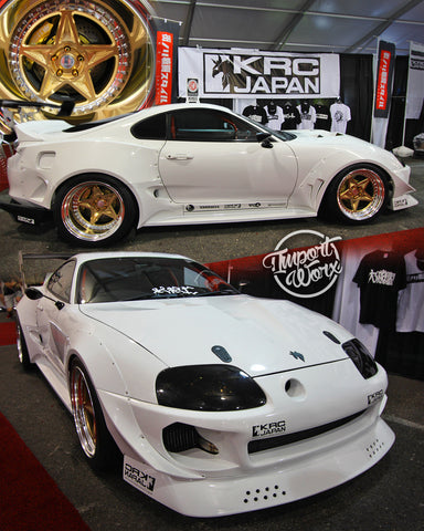A white Toyota Supra with gold wheels and a widebody kit, displayed at SEMA 2018.