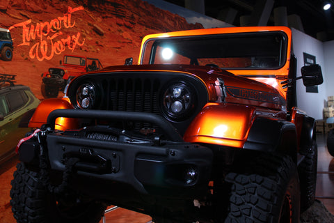 A photo of the Jeep Wrangler CJ66 Concept, a customized off-road vehicle with a mix of classic and modern design elements. It features a black and silver color scheme, large off-road tires, and various aftermarket parts and accessories.