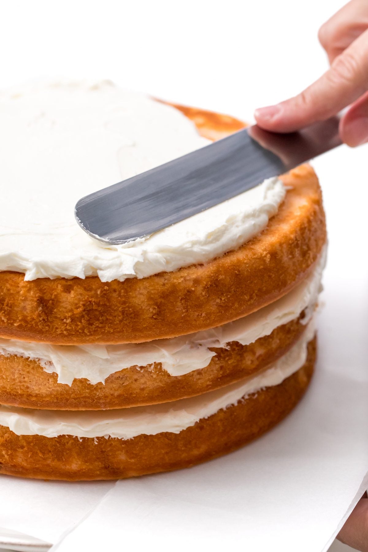 DISTRIBUTE THE ICING EVEN OVER THE LAST LAYER OF CAKE