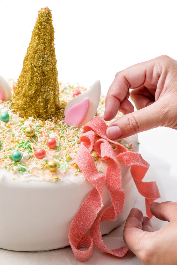 hacer un pastel de unicornio con dulces como decoración