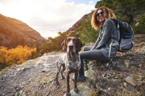 Woman on a hike sitting with her dog