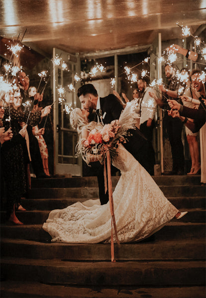 Groom Kissing Bride in Grand Wedding Sparkler Exit