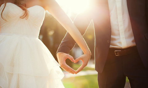 Bride and Groom Creating Heart With Hands