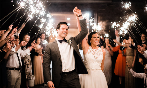 Couple walking through their exit with 36 inch wedding sparklers