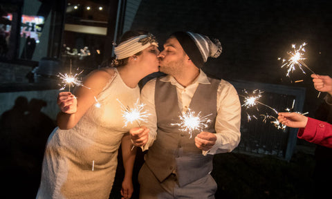 Husband and wife holding sparklers together before their send off