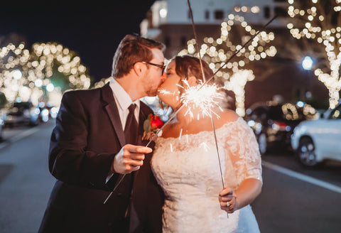 Bride and groom sharing a kiss with the warmth and glimmer of 36 inch wedding sparklers