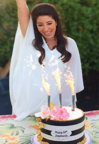woman using cake sparklers for her birthday celebration