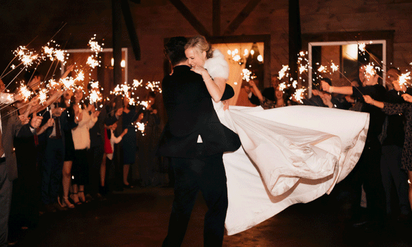 Bride and Groom embracing during 36 inch wedding sparkler send off