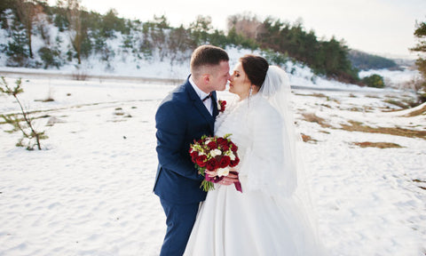 groom embracing bride wearing shaw in the winter