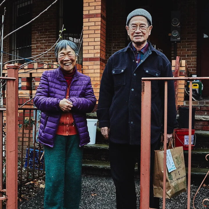 Smiling elderly Asian couple served by Heart of Dinner