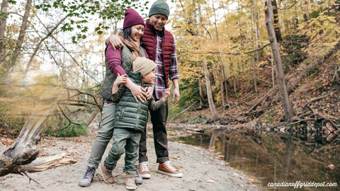 family of three has fun hiking near a stream at their off grid cottage