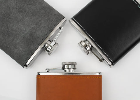 Selection of leather engraved hip flasks with brown, black and grey leather