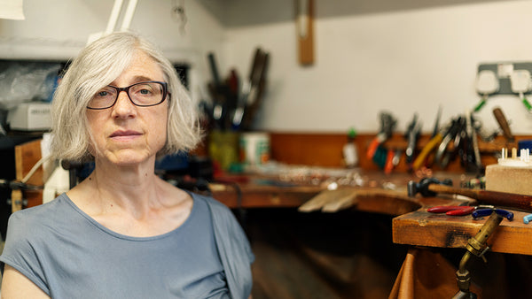 The maker sitting in her studio, looking at the viewer.