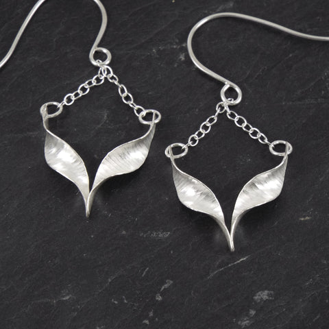 Silver drop earrings - a twisted chevron shape suspended from each point to the ear wire by a short chain