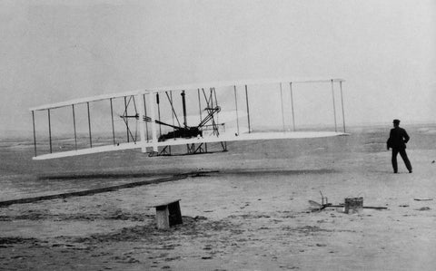 A photo of one of the Wright Brothers first flights at Kitty Hawk on 12-17-1903.