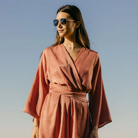 A model wearing Cecil aviator sunglasses named after Cecil "Teddy" Kenyon, a female test pilot for Grumman aircraft during WWII.