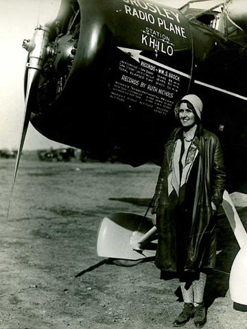 A photograph of Ruth Nichols standing beside the Lockheed Vega 5 in which she set all of these records.