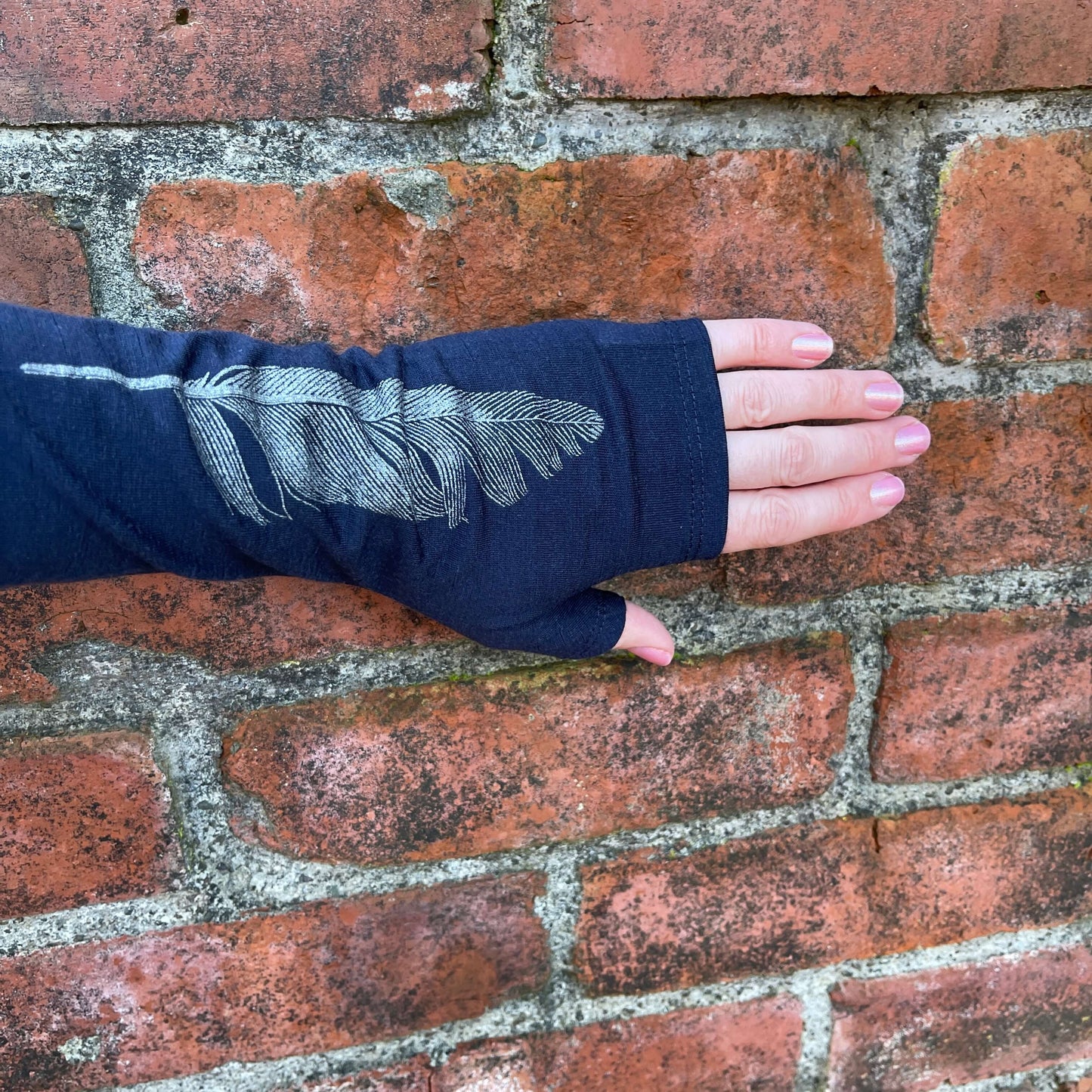 Fingerless merino gloves in navy with a silver feather print.