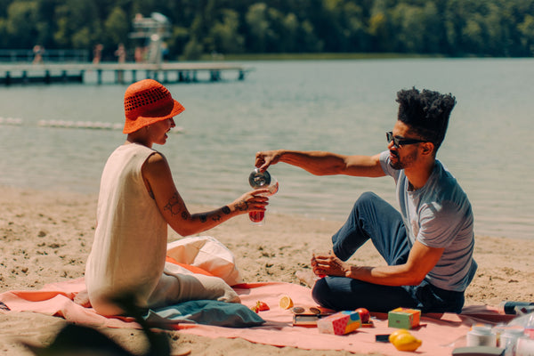 Two persons drinking iced tea by the lake