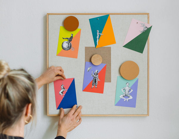 Frau hängt Masterblend Colorblocking Postkarten an die Wand