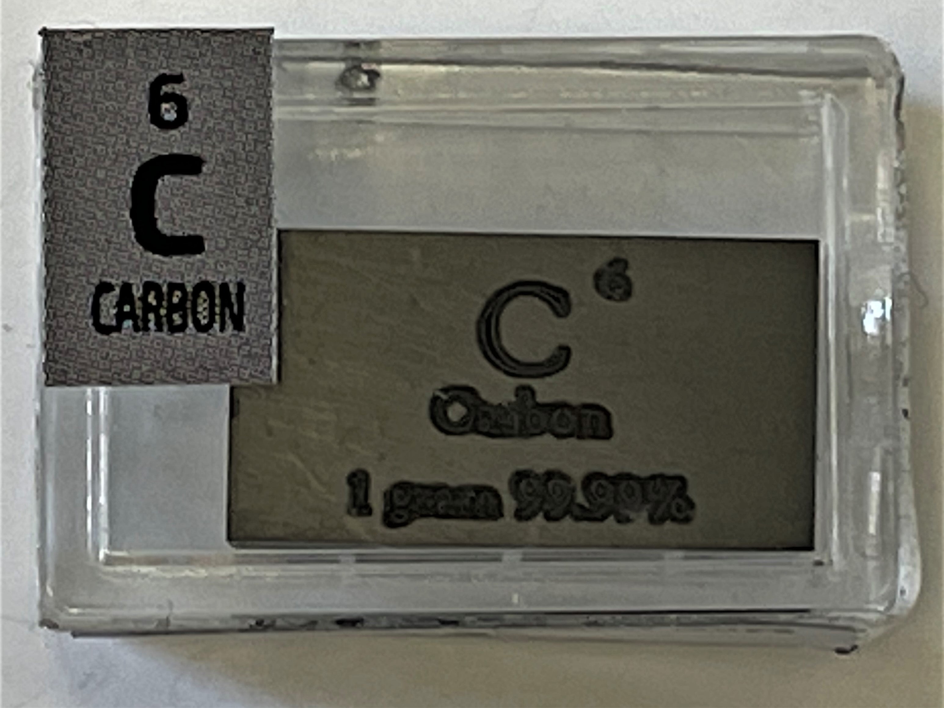 Carbon pure Solid 1 Gram Ingot Bullion 99.99% in a labeled Periodic Element Tile