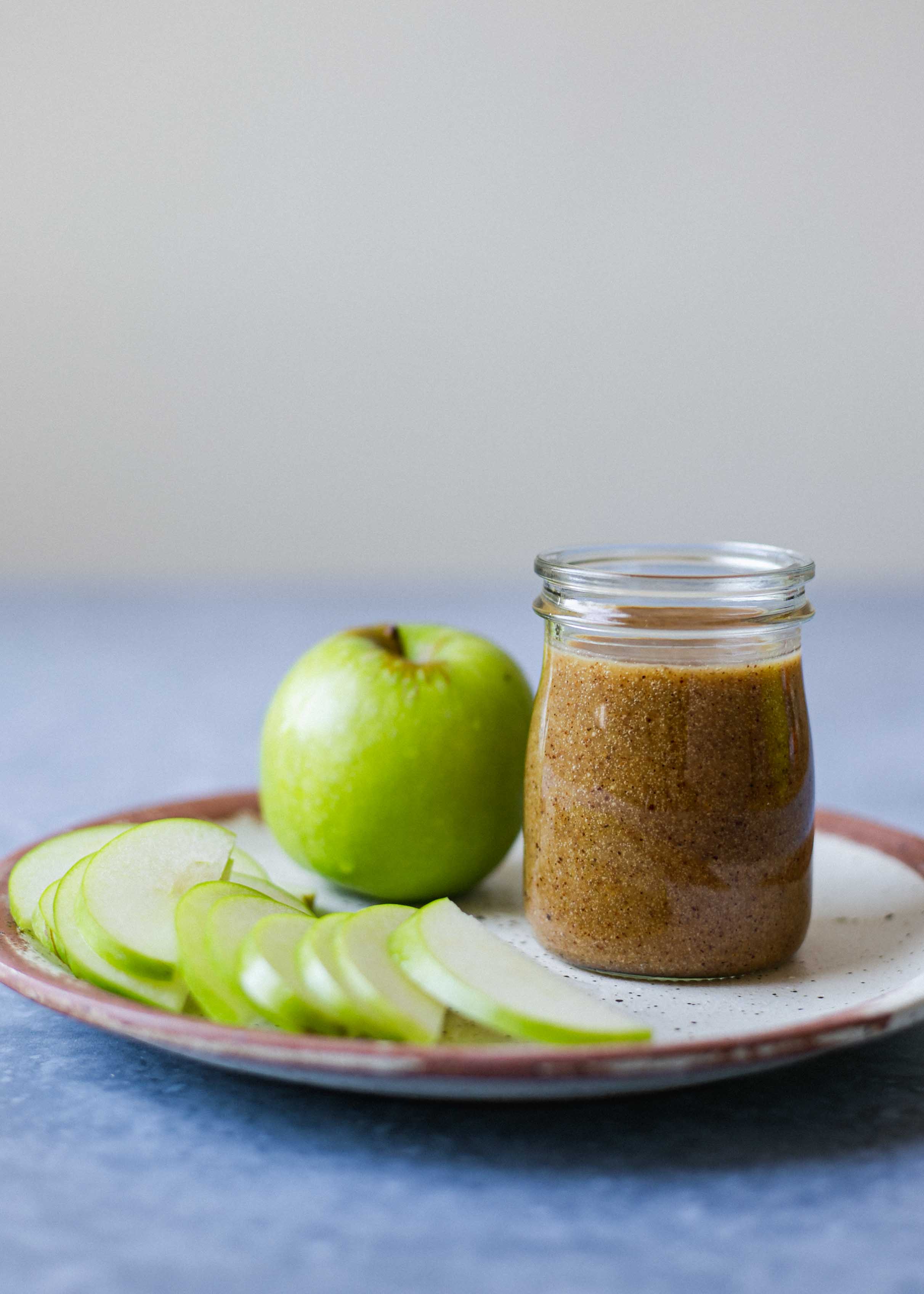 Almond butter caramel apples next to a jam jar