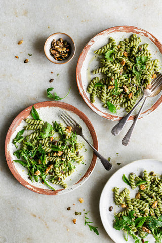 Two plates of pesto pasta salad