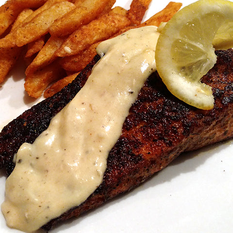 Brozzian's Blackened Cajun Salmon drizzled with sauce and served with fries