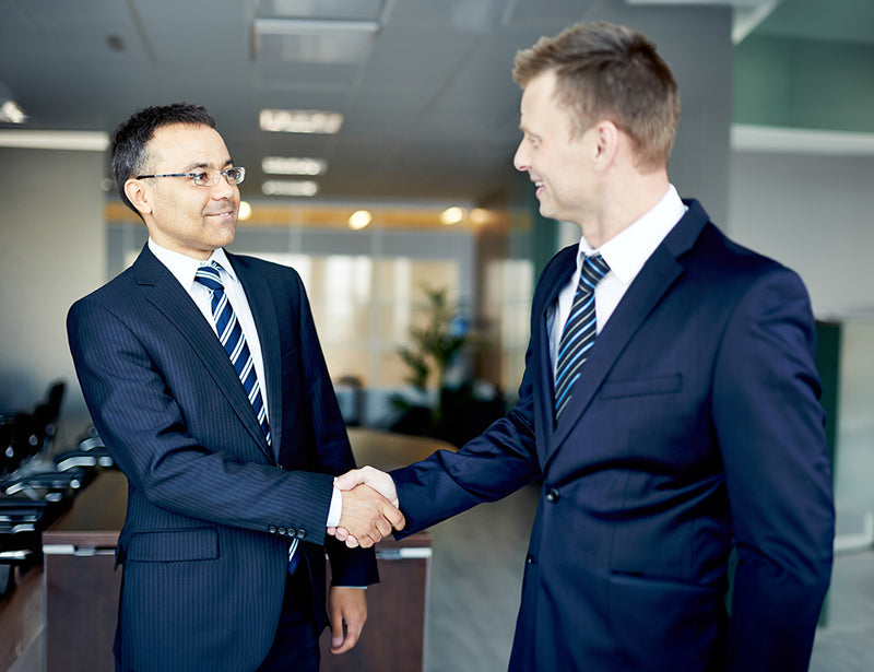 two business people shaking hands smiling