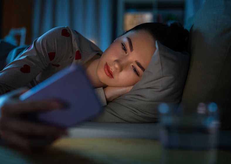 a girl using her phone in bed.