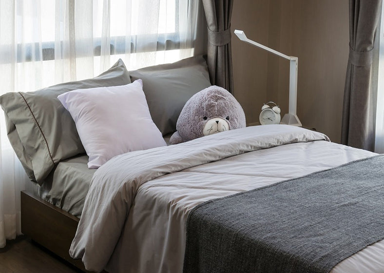 A neat and clean bed with a highly supportive mattress, pillows, and other accessories