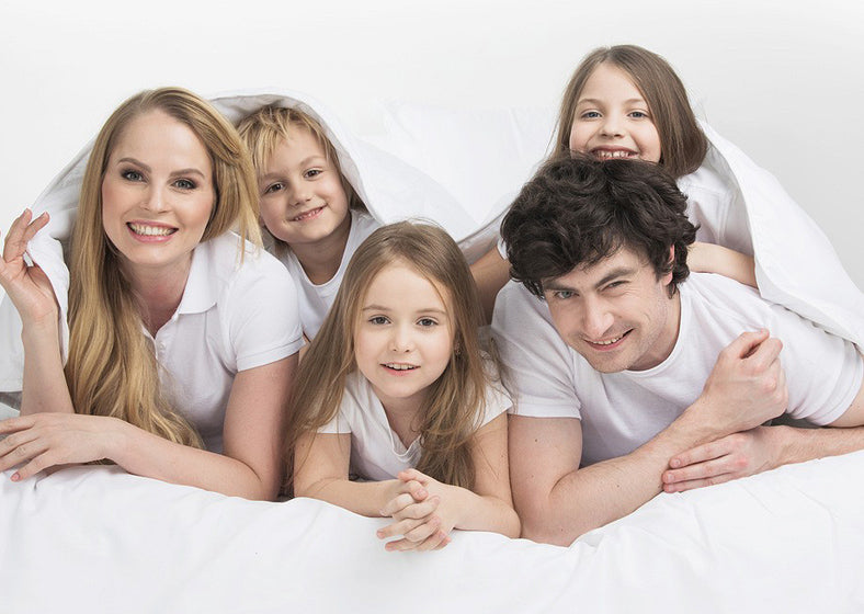 Family with three children on an oversized mattress