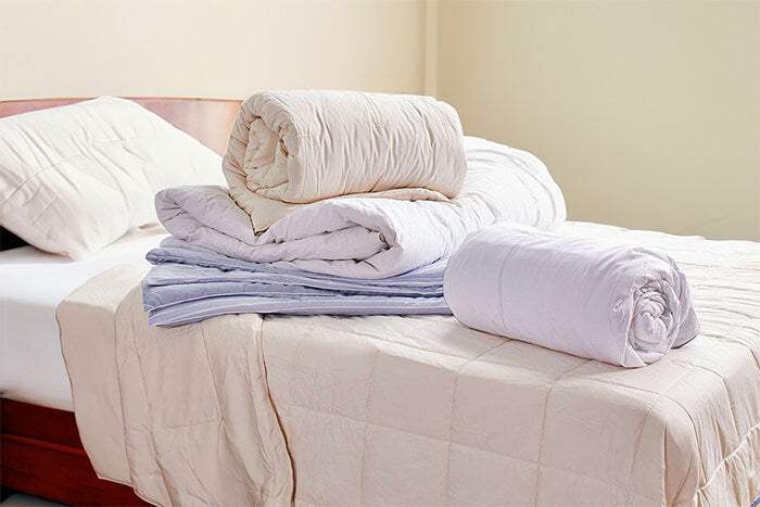 comparative image of heavy, medium and light weight comforter