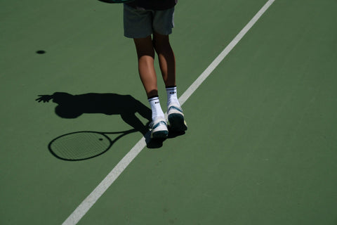 Men's tennis socks. Tennis player serving.