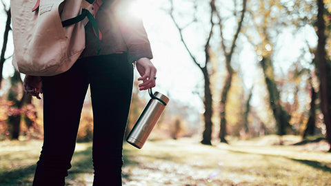 woman holding waterbottle on trail