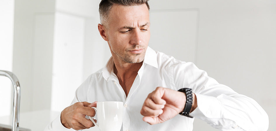 Man looking at his watch while dosing cbd coffee.