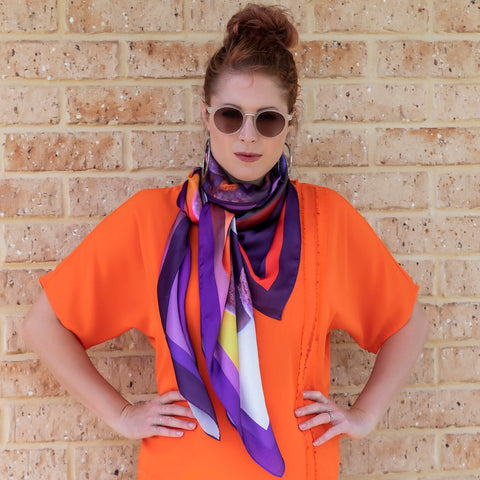lady in coral top wearing colourful vino square scarf