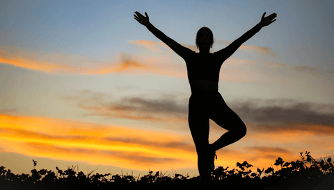 Mujer haciendo yoga en atardecer