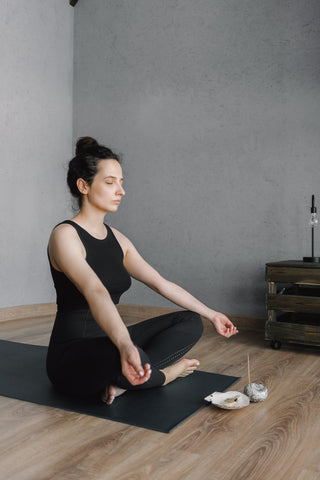 woman sitting with legs crossed meditating
