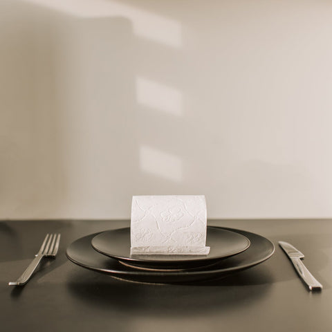 A single place setting with a note on the plate.