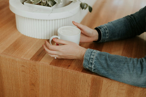 Hands holding a mug.