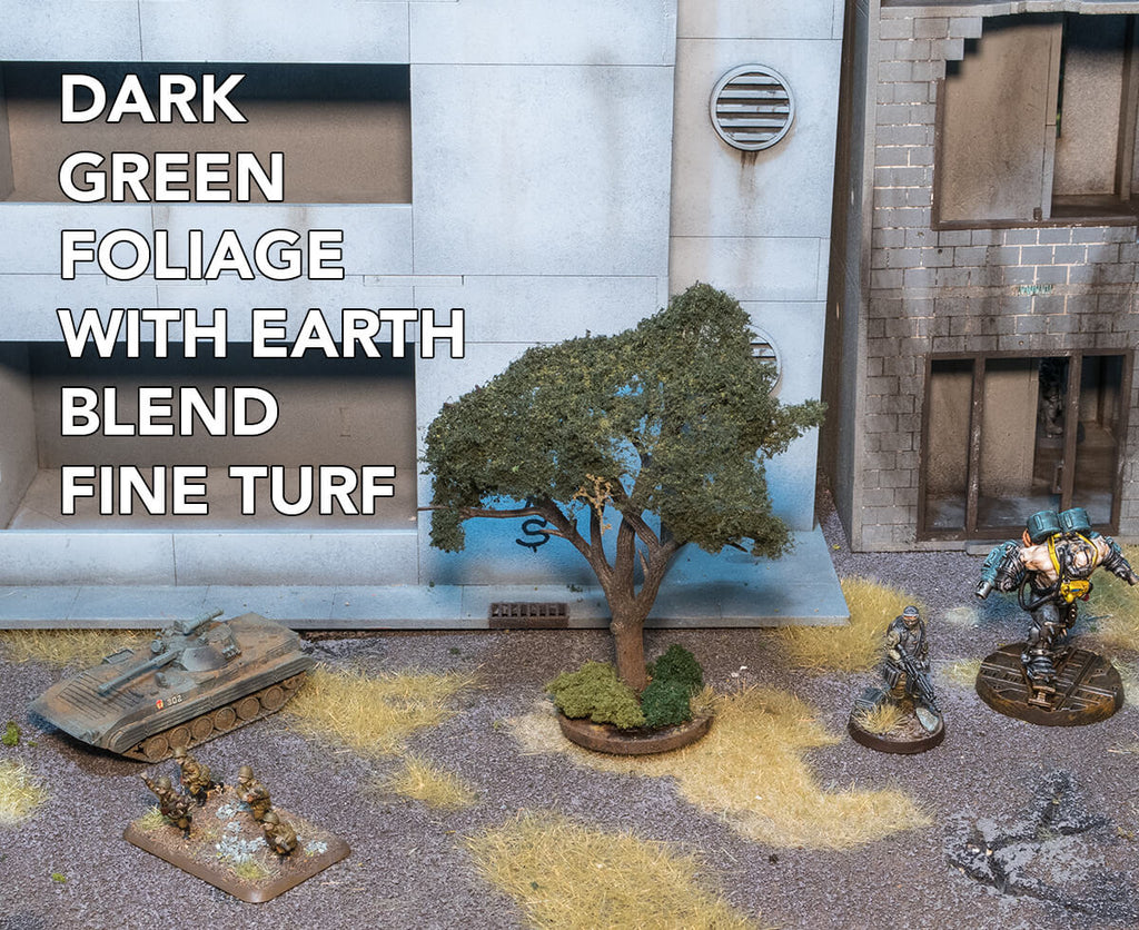 Woodland Scenics Foliage with a flocking of eath blend fine turf. Foliage is stretched over the tree armatures to make realistic model tree wargaming terrain. Miniatures shown for scale.