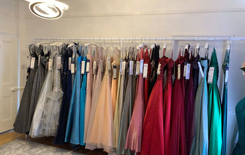 A wall displaying a rack of dresses, ideal for affordable bridal shopping near me.