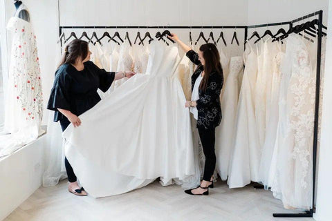 Two women browsing wedding dresses in a shop