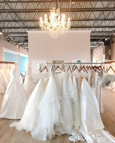 A boutique showcasing numerous luxury boho wedding dresses elegantly displayed on racks.