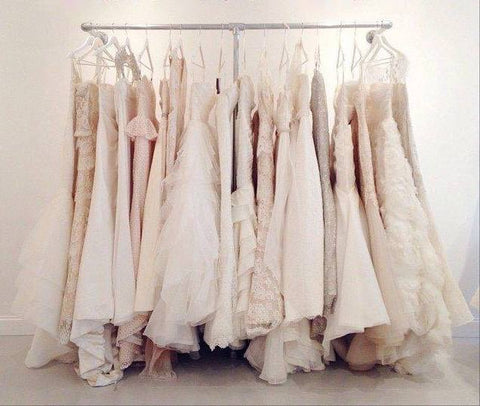 A collection of elegant wedding gowns on display for custom bridal dress sales.